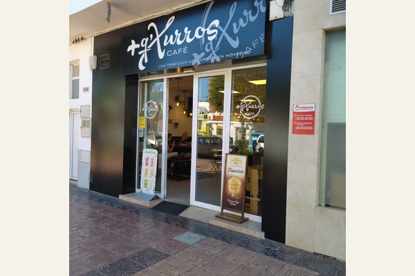 Fachada del local de Churros Coffee Shop, con el rótulo Más Que Xurros Café, en Vecindario Fachada del local de Churros Coffee Shop, con el rótulo Más Que Xurros Café, en Vecindario
